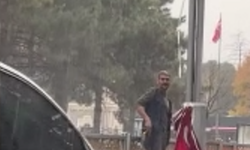 Yağan yağmura aldırmadan düşen bayrakları topladı
