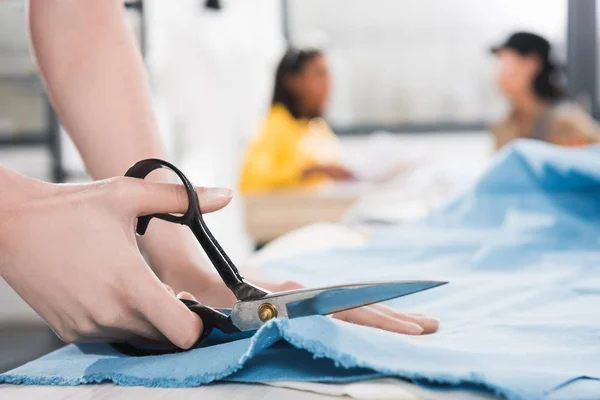 Stock Photo Young Dressmaker Cutting Fabric With Scissors